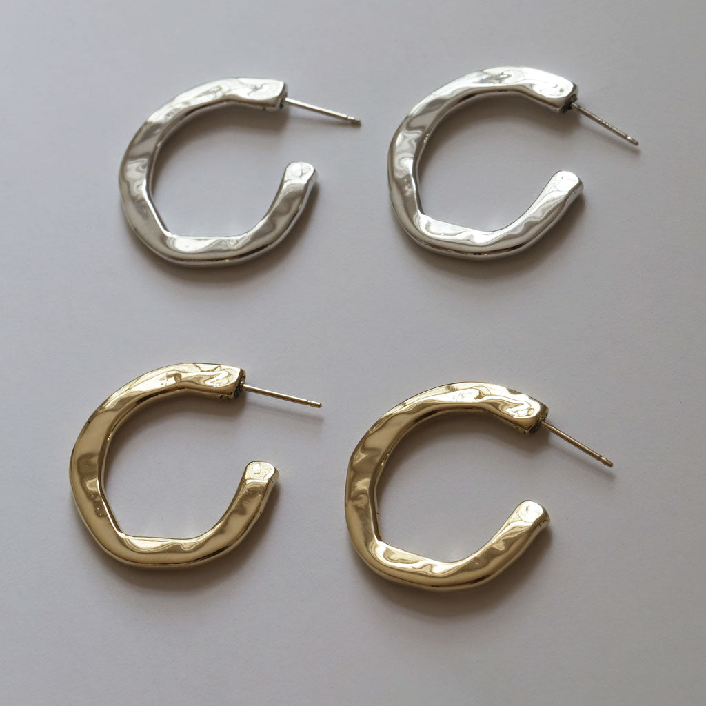 a pair of silver and gold irregular C shaped hoop earrings
