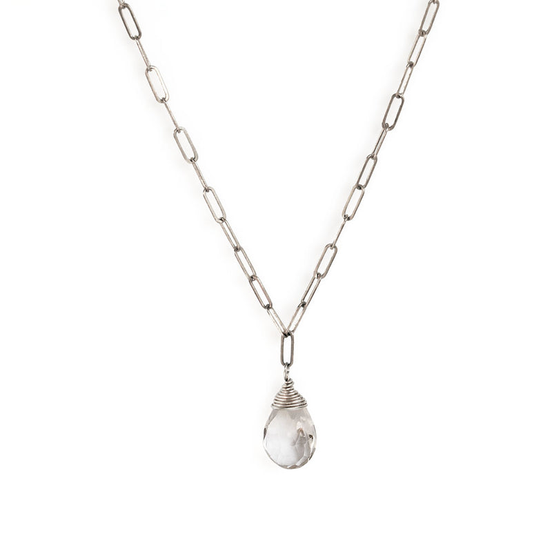 crystal quartz and silver chain necklace on white background