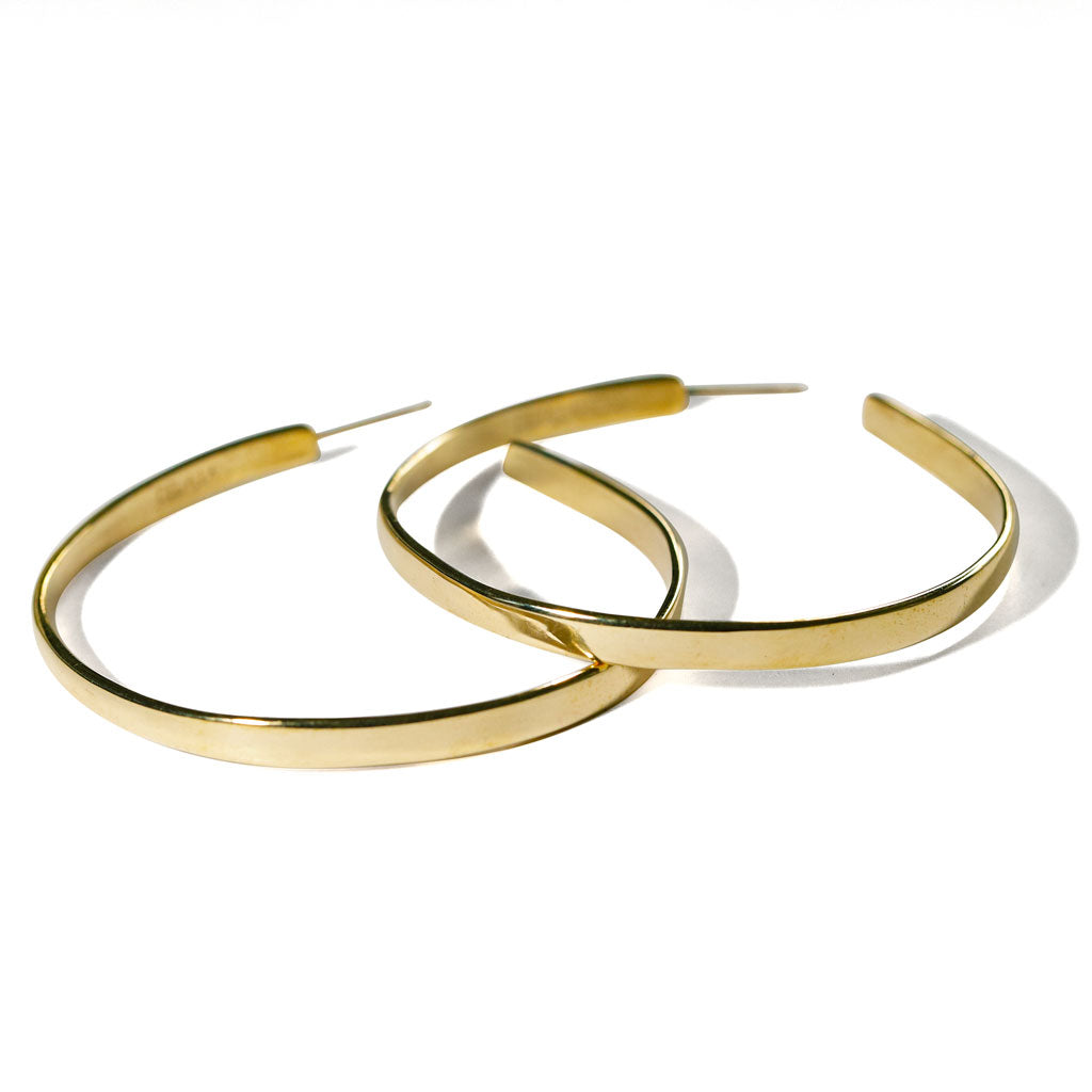 large flat gold hoop earrings on white background