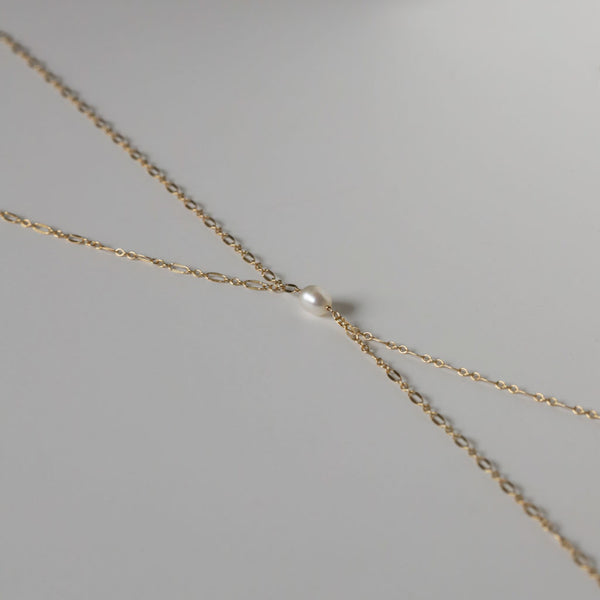 side view of a gold filled chain and single pearl necklace
