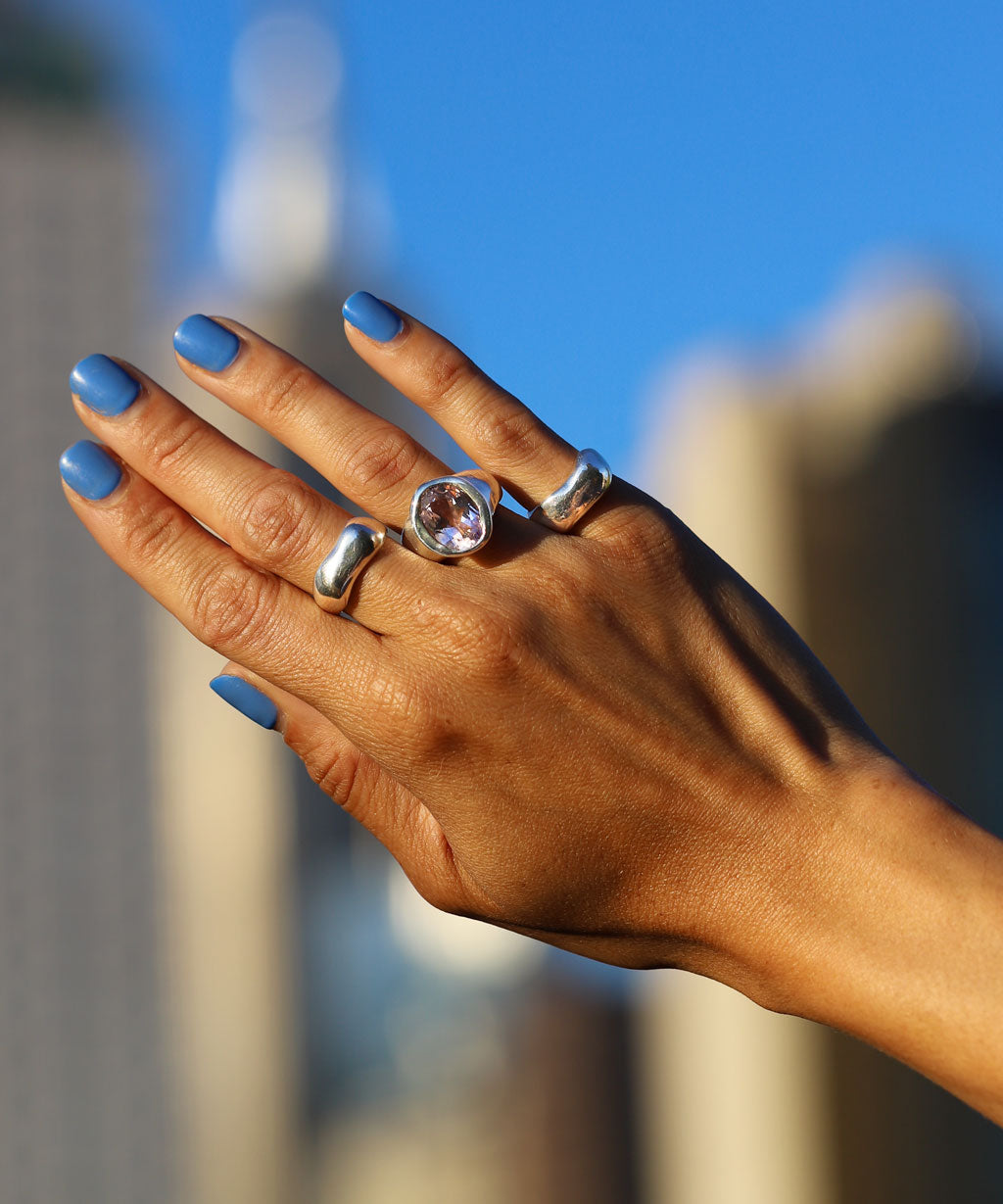 hand with chunky silver and pink amethyst rings