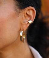 ear with wide gold hoop and cartilage hoop 