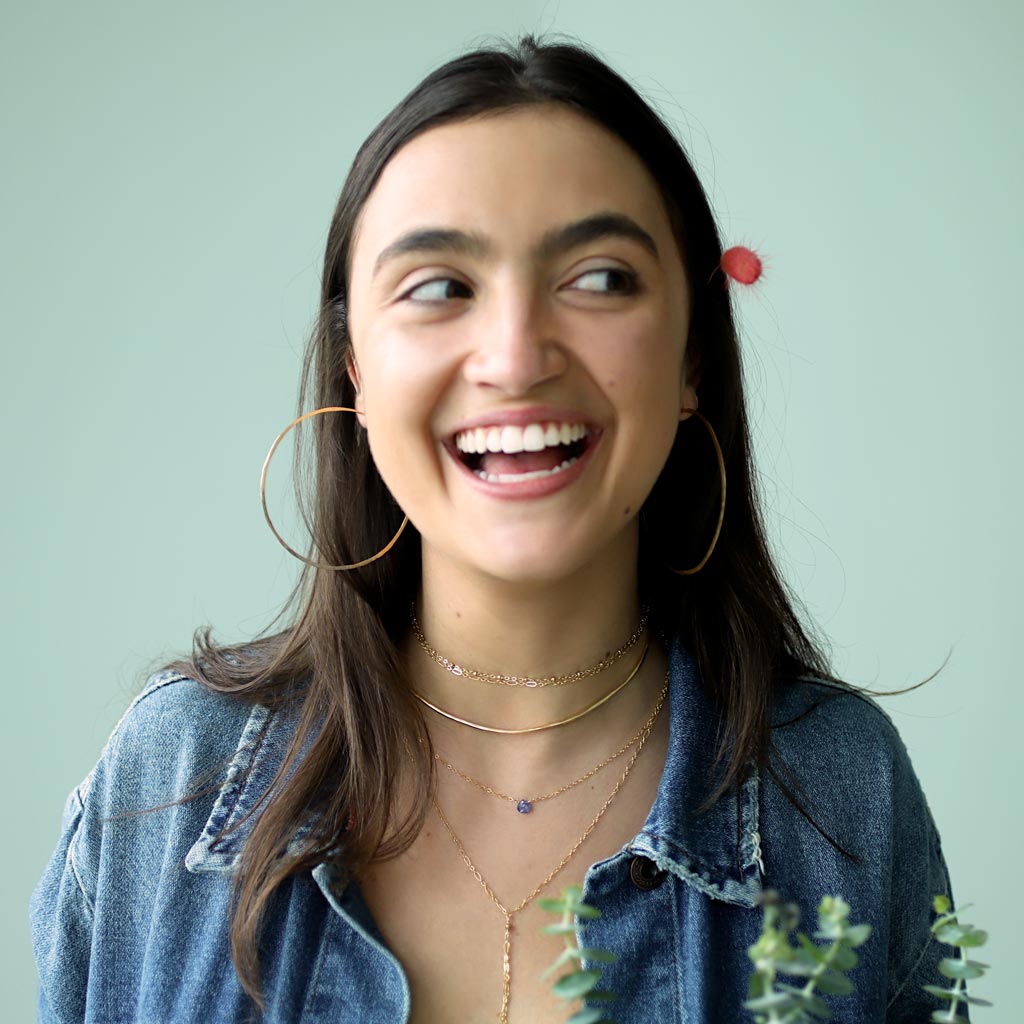 girl laughing with delicate gold layered jewelry