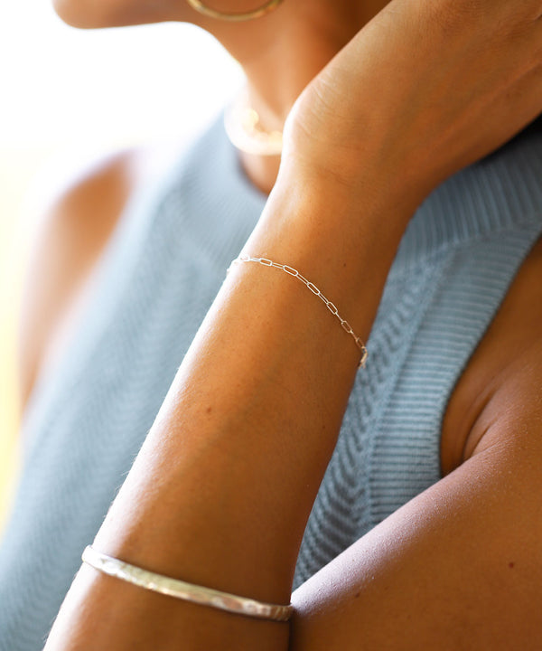 woman's arm with silver bracelets