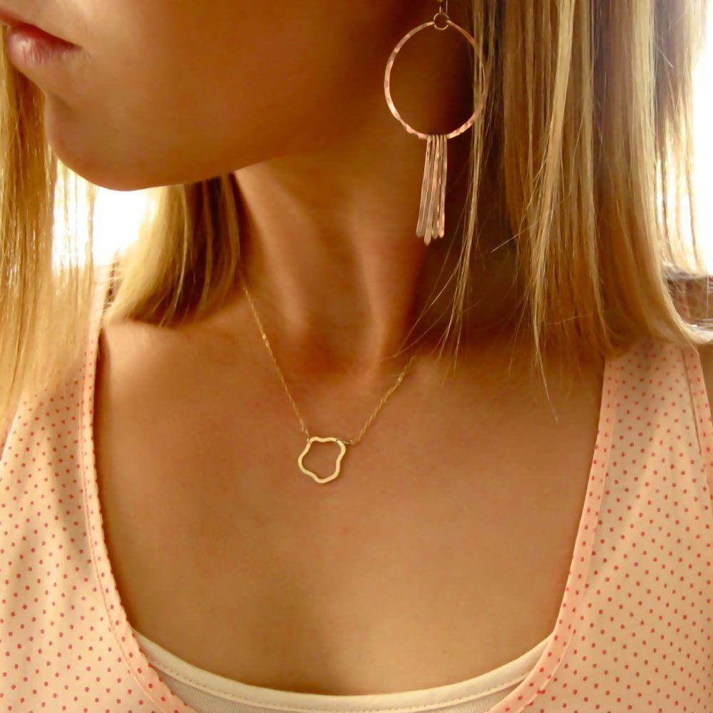 blond woman on a pink with red dots tank looking to the side wearing rose gold filled round fringe hoop earrings