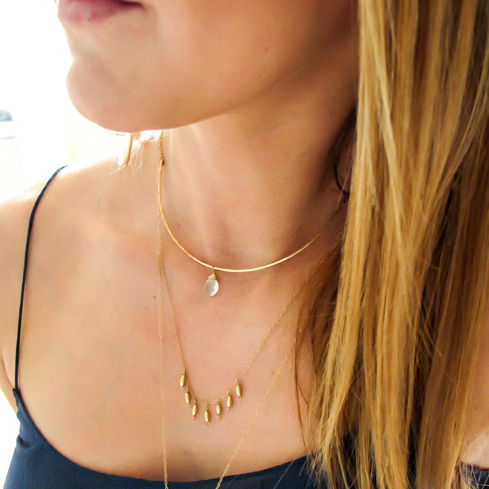 blond woman on a navy blue top wearing a 14k gold filled gold grain necklace