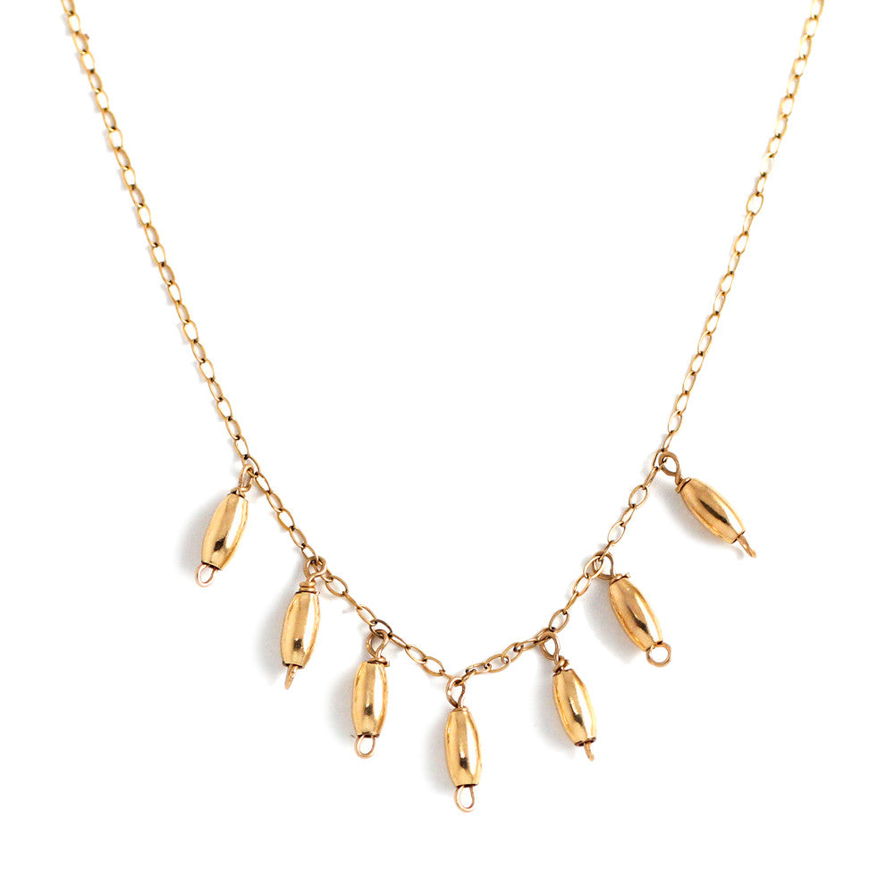 14k gold filled gold grain necklace on a white surface