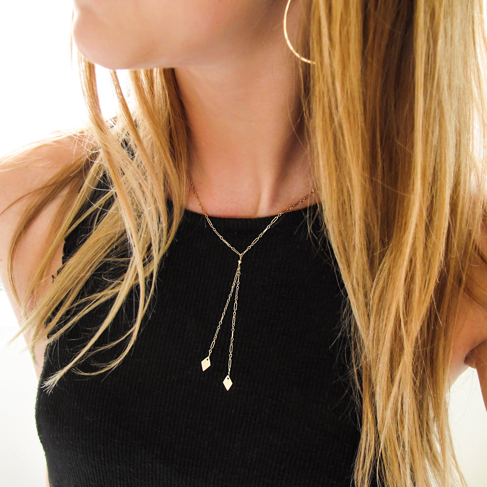 gold y shaped lariat necklace with geometric charms