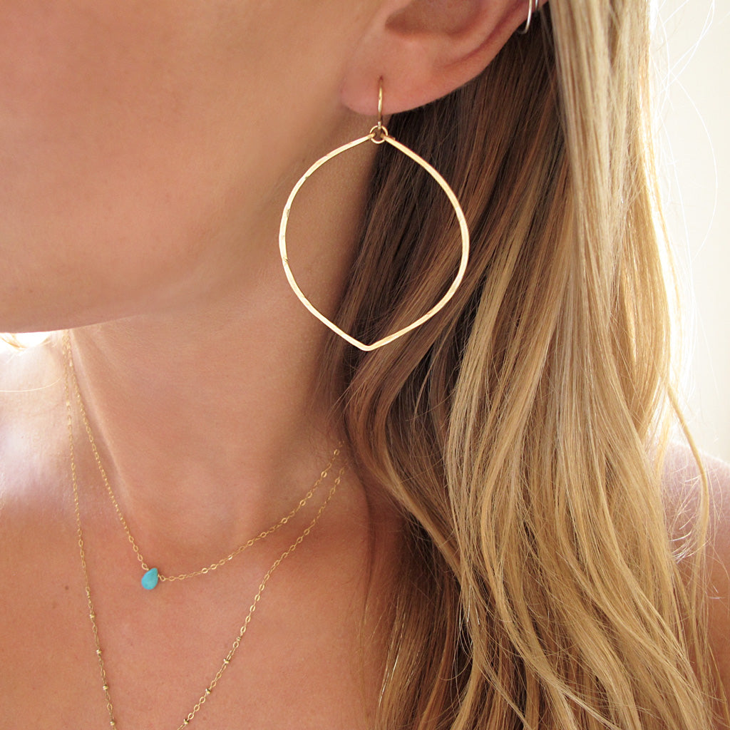 blond woman ear closeup wearing rose gold filled fig hoop earrings