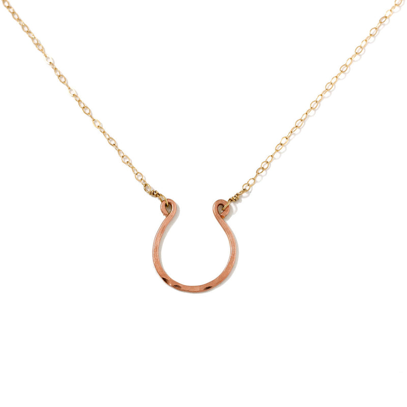 rose gold filled good luck horseshoe necklace on a white surface