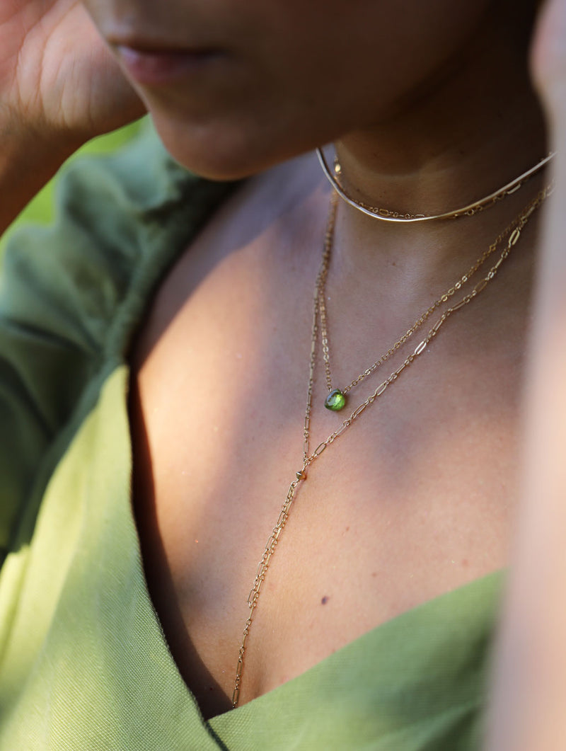 brunette neck close up wearing 14k gold filled peridot short gemstone necklace tied up choker wrap necklace and halo collar