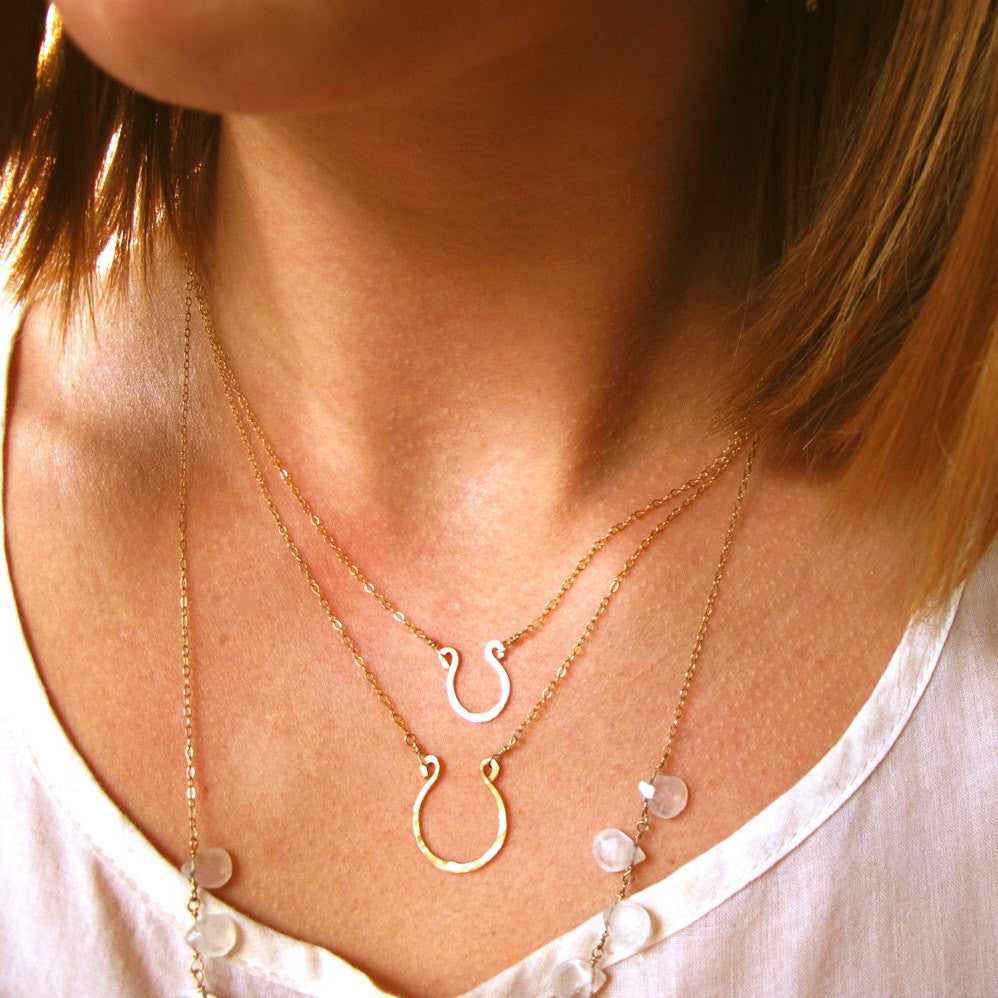 tiny gold horseshoe pendants by delia langan jewelry