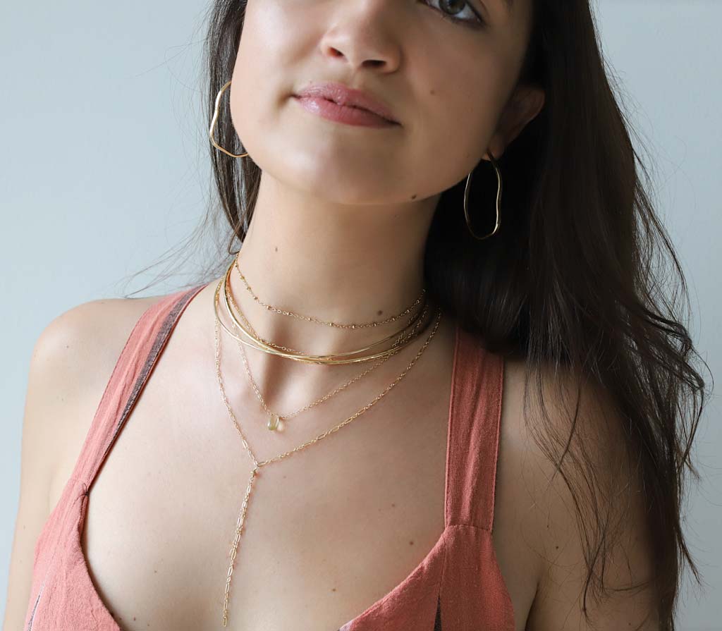 brunette on a pink top wearing a 14k gold filled tied up choker wrap necklace