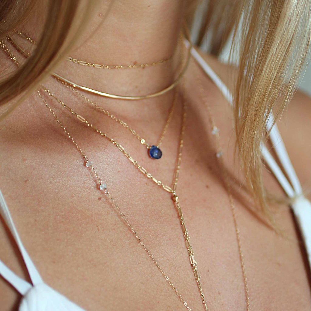 blond woman on a white top neck closeup wearing a 14k gold filled tied up choker wrap necklace