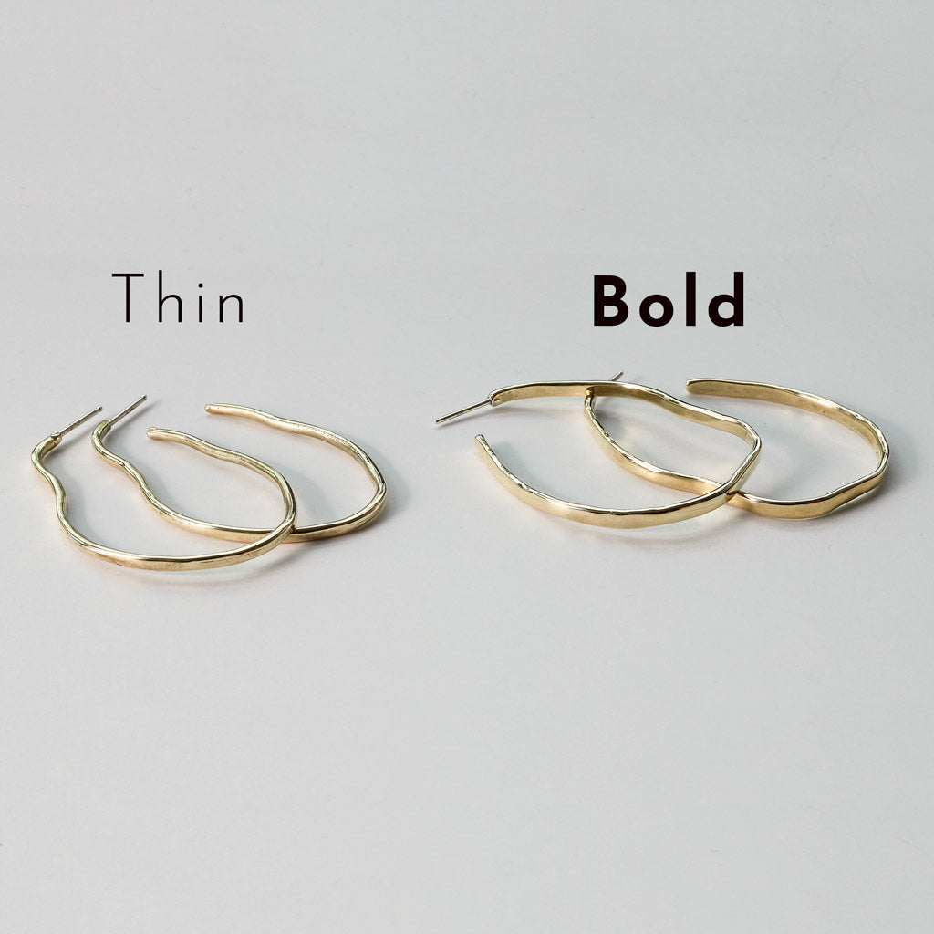 brass with sterling posts maeve thin hoop earrings next to brass with sterling posts maeve bold hoop earrings on white surface