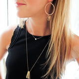 blond woman on a black tank wearing 14k gold fill moonstone short gemstone necklace and xl different strokes fringe pendant