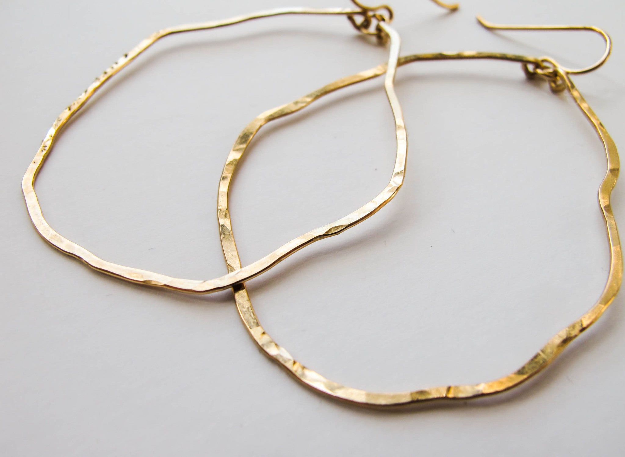 gold wavy irregular hoop earrings hand hammered and handmade by delia langan jewelry