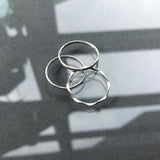 delicate silver rings on reflective surface
