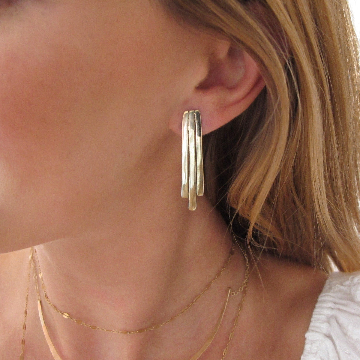 blond woman ear closeup wearing gold brass small fringe post earrings