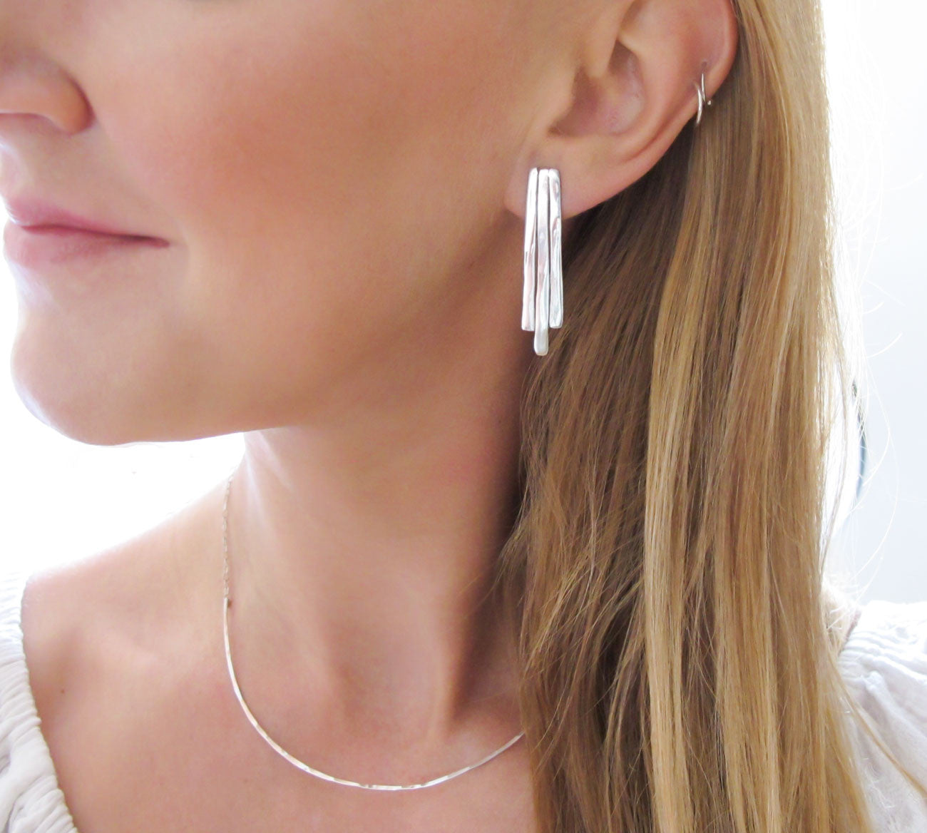blond woman neck closeup wearing sterling silver small fringe post earrings