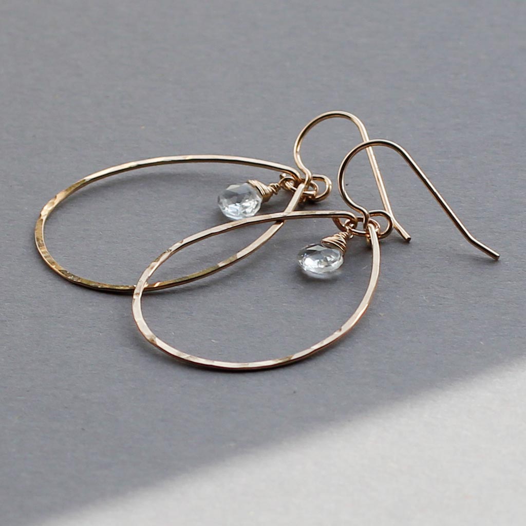 white topaz and thin gold oval hoop earrings