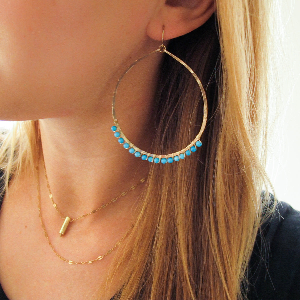 blond woman ear closeup wearing 14k gold filled turquoise xl gemstone arc hoops