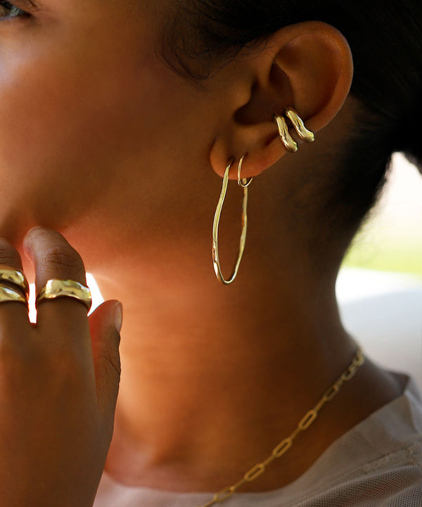 ear with gold hoops and three cartilage hoop earrings