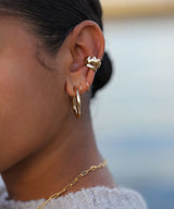 ear with stacked chunky ear cuffs cartilage hoops and hoop earrings in gold