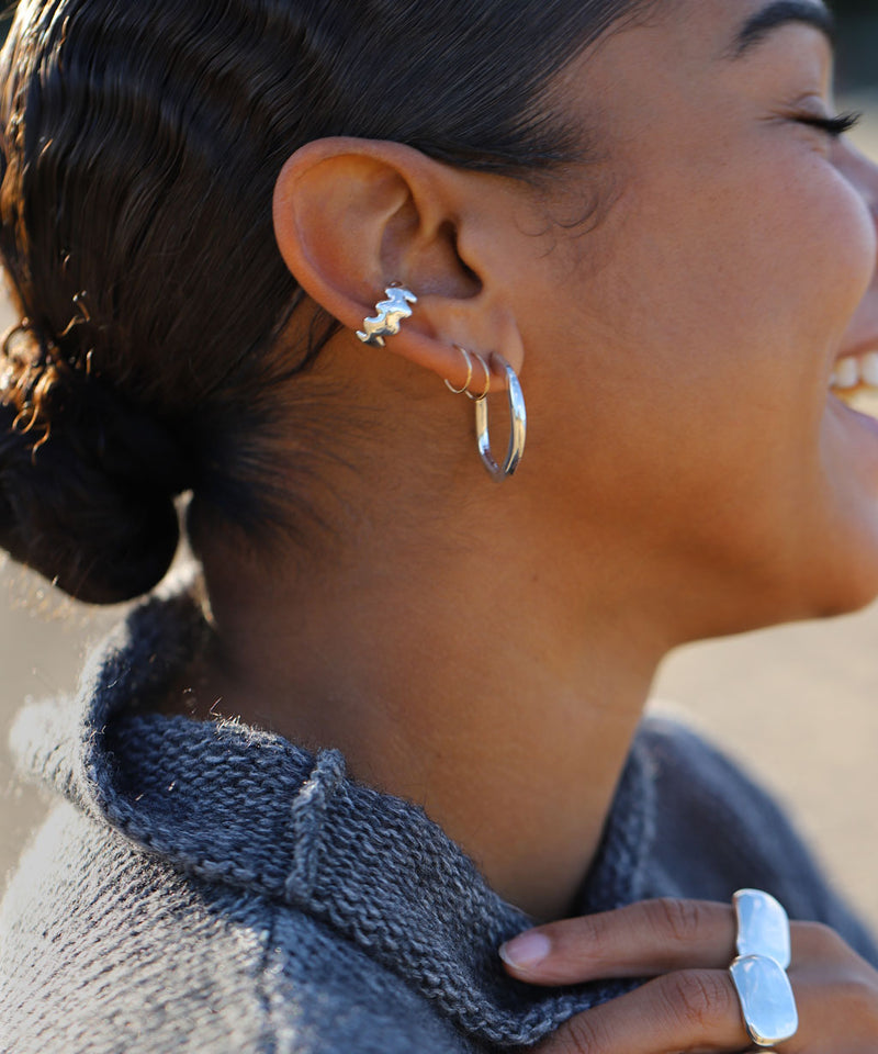 closeup of side view of girl with chunky handmade silver earrings