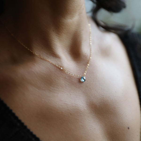 london blue topaz and gold chain pendant on neck