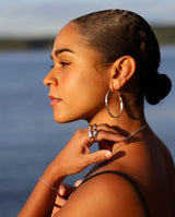 girl with sun shining on her face with bright silver rings and earrings