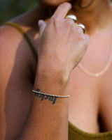 girls wrist with tattoo and gold rope chain bracelet