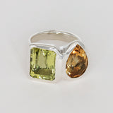 Silver ring with green and orange gemstones on a white background