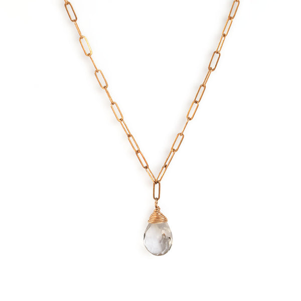 crystal quartz and gold chain necklace on white background