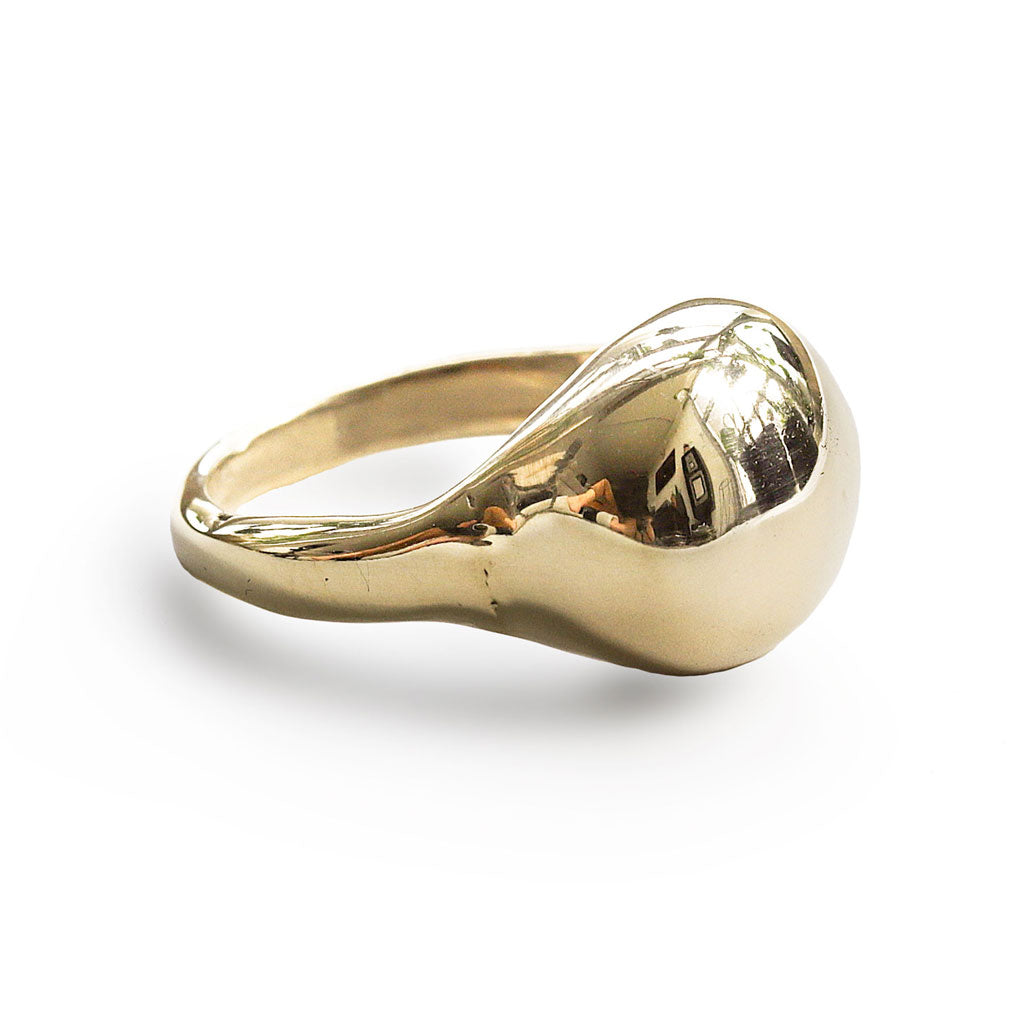 brass globe ring on white surface by delia langan jewelry