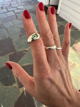 Hand with two silver rings on a stone pavement background