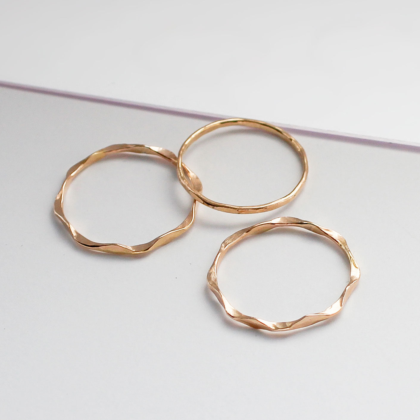 three wavy and flat thin gold stacking rings