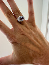 pink amethyst ring on hand against white background