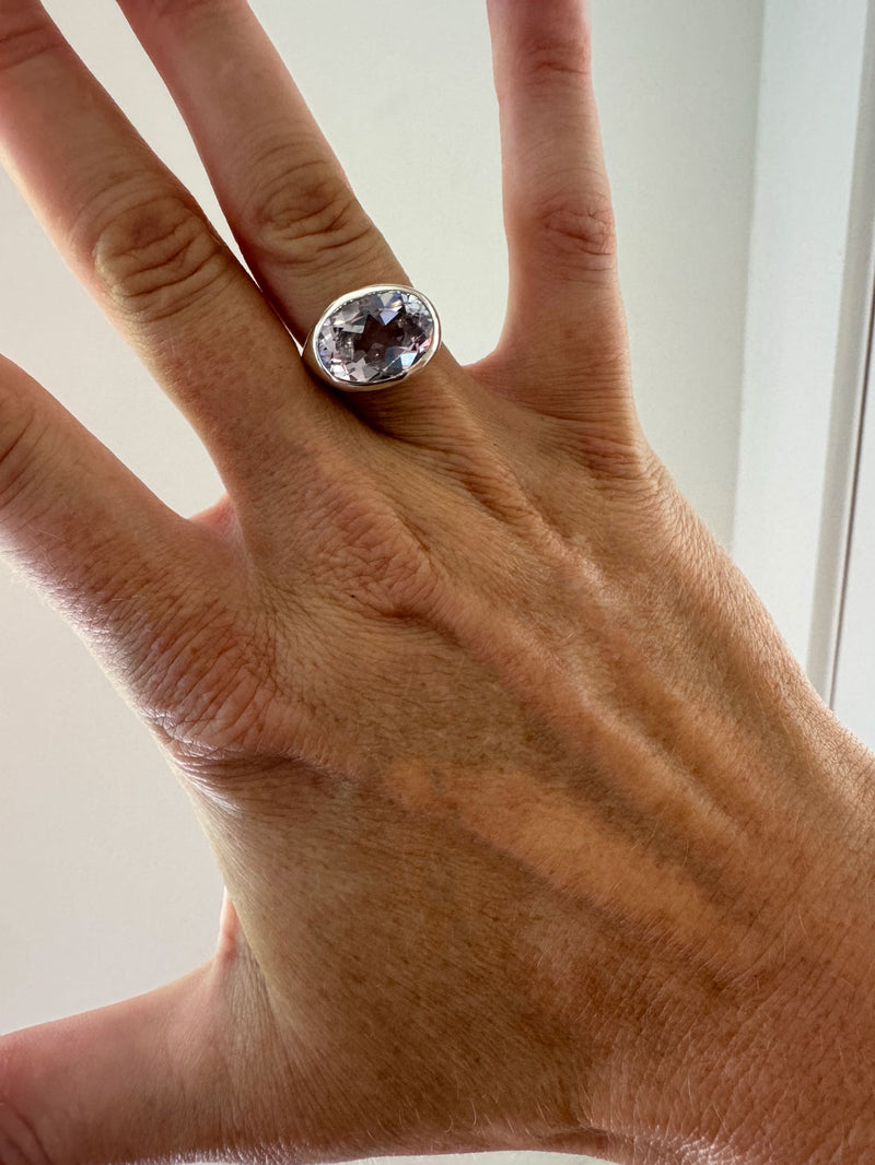 pink amethyst ring on hand against white background