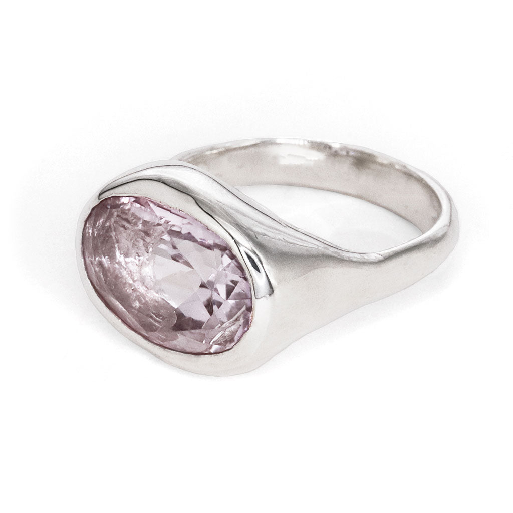 Silver ring with a pink gemstone on a white background