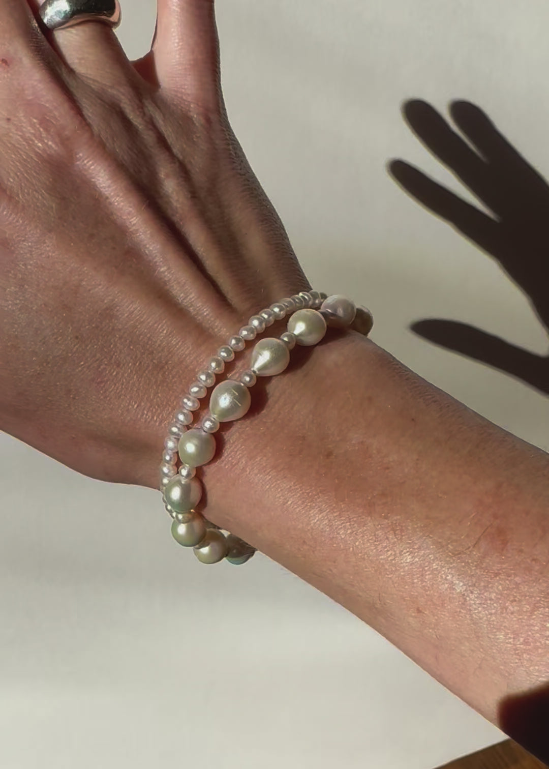 video of wrist with two white freshwater pearl bracelets