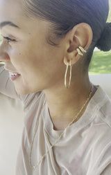 video of girl wearing organically shaped gold cartilage ear cuffs and hoops
