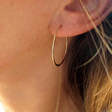 1" diameter thin gold hoop earrings on ear