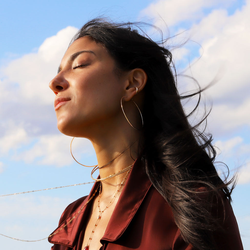 girl with hoops and hair blowing in the wind