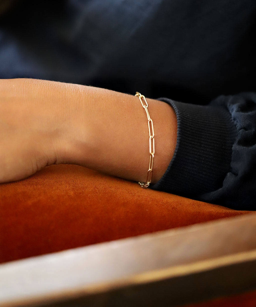 large gold paperclip chain resting against orange velvet