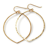 14k gold filled fig hoop earrings on a white surface partially reflecting light