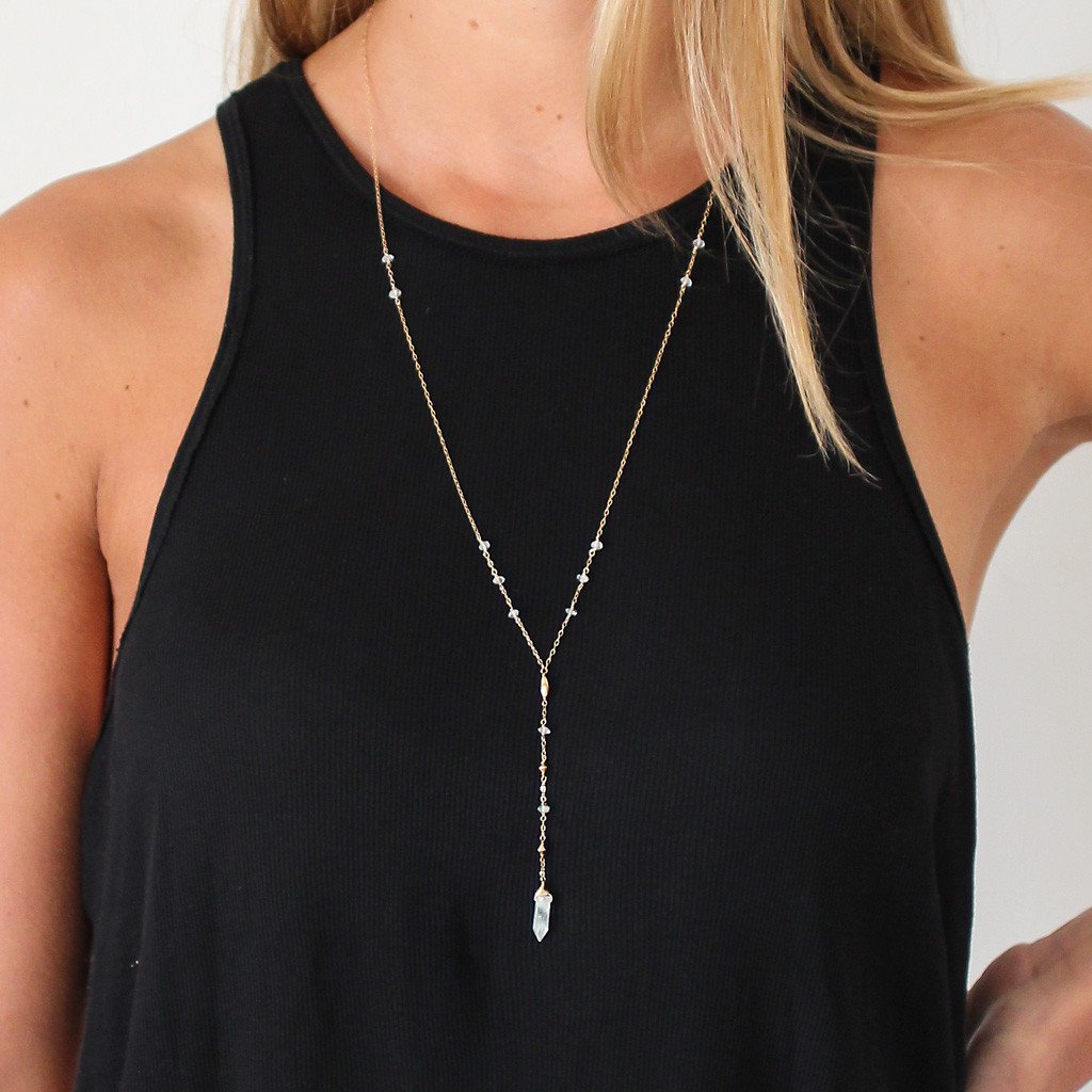 blond woman on a black tshirt wearing a 14k gold filled aquamarine y gemstone necklace