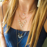 blond woman on a navy blue top wearing a 14k gold filled gold grain necklace