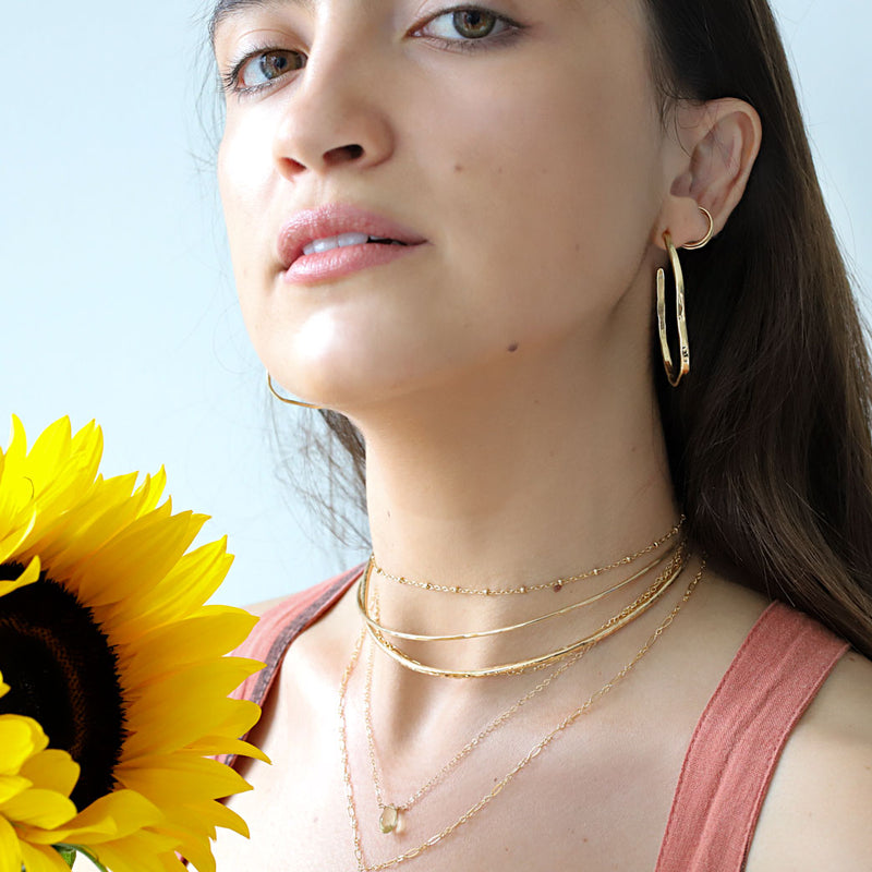 brunette wearing 14k gold filled lemon quartz short gemstone necklace choker necklace halo collars and maeve hoop earrings