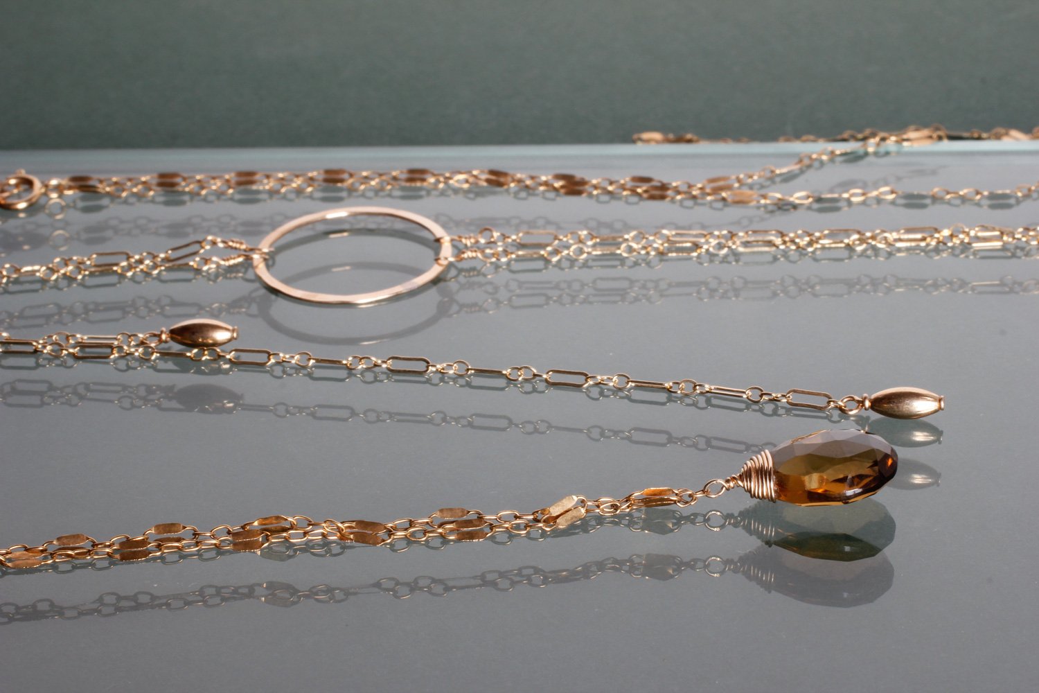 14k gold fill beer quartz choker wrap gemstone necklace and 14k gold fill medium bolo y necklace on grey glass surface